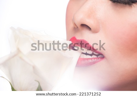 Asian woman beauty face closeup portrait. Beautiful attractive Asian model with perfect skin and blended red lips isolated on white background. Fashion studio shot of beautiful young woman