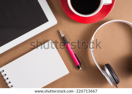 Contemporary Office Desk with Computers and Office Tools. view of the office tools on Cardboard. Blank paper and colorful pencils on the wooden table. View from above