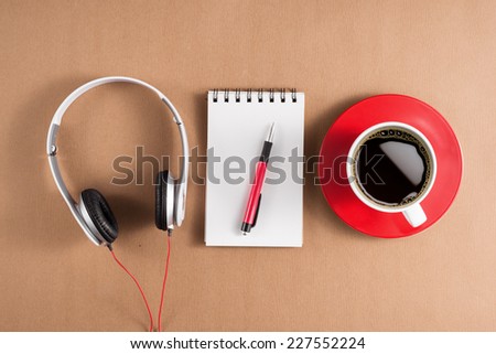 Office table with notebook, headphone and coffee cup. View from above with copy space