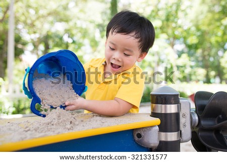 Close up of little child playing at playground. Outdoor spring activity.