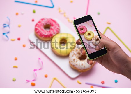 Similar – Image, Stock Photo Taking photos of donuts with the smartphone. Photographing food top view.