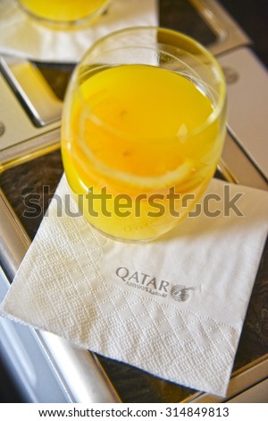 DOHA, QATAR - Mar 21 2014: Napkin with Qatar Airway Logo and Orange Juice serving in the business class of Qatar Airways