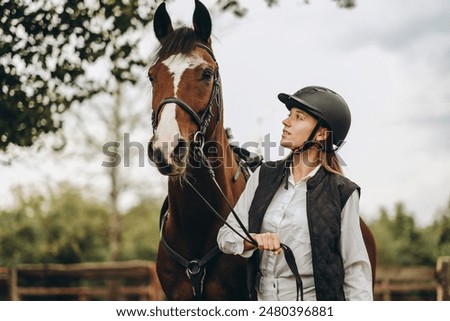 Similar – Image, Stock Photo Woman in jockey outfit standing with horse