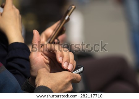 Cell phone and smart phone in his hands.