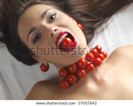 portrait of a beautiful woman with a tomato in her mouth