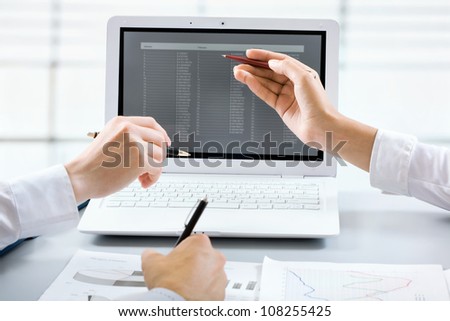 Close-up of businesswoman explaining a financial plan to colleagues at meeting