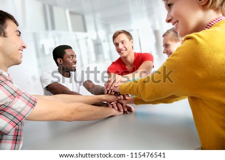 Team of friends showing unity with their hands together
