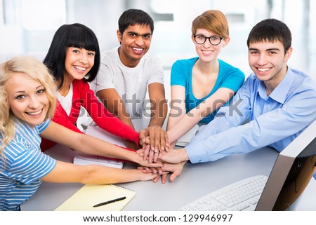 International group of students showing unity with their hands together