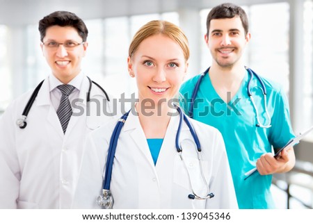 Portrait of a smart female doctor sitting in front of his team and smiling