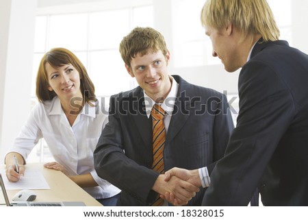 Photo of businessmen  handshaking with woman near by