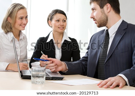Image of business conversation of three businesspeople
