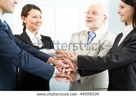 Cheerful business people joining their hands