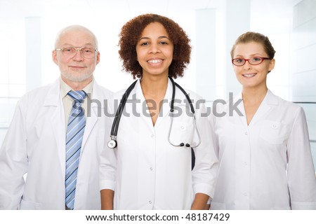Group of doctors stand in a hall of modern hospital