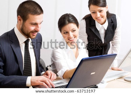 Portrait of executive employees looking at laptop monitor and discussing new project