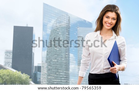Beautiful young businesswoman among the skyscrapers of the modern business center