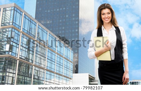 Beautiful young businesswoman among the skyscrapers of the modern business center