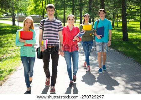 Full length of happy college students walking together