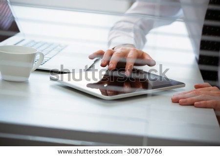 Close-up of hands of business man working on a tablet computer.