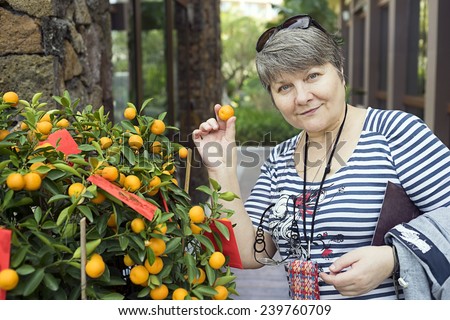 Russian tourist near Cristmas tangerine tree mandarin duck in his hand