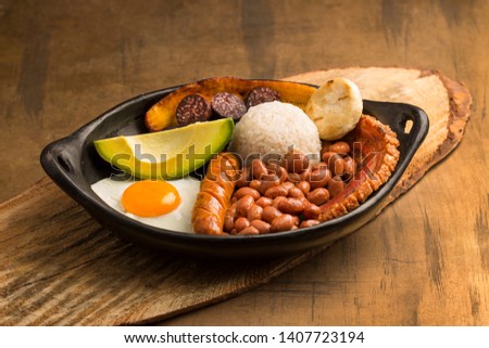 Bandeja paisa, typical dish at the Antioqueña region of Colombia. It consists of chicharrón (fried pork belly), black pudding, sausage, arepa, beans, fried plantain, avocado egg, and rice Foto stock © 