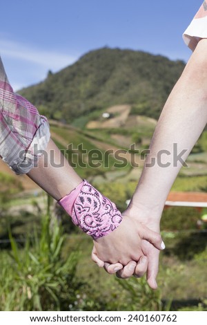 Hands clasped nature background