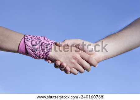 Hands clasped blue sky background