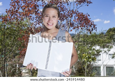 Latin woman with notebook outdoors