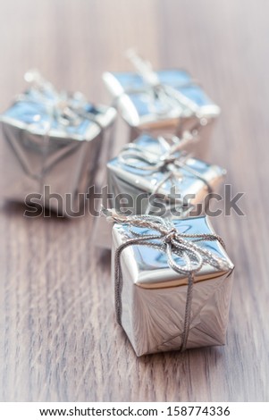 Silver decorative gifts on wooden background