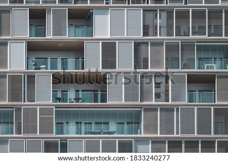 Similar – Foto Bild Geometrische Frontalansicht der Fensterläden und Balkone eines städtischen Gebäudes, die in fortlaufenden Reihen angeordnet sind