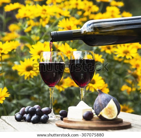 Relax concept - wine party outdoors. Wine is pouring to the glass.