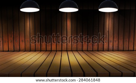 Illuminated spot lighting over dark background and wood floor