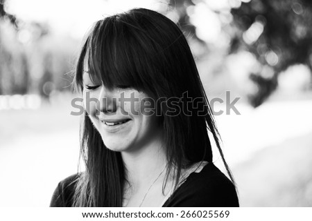 Girl cries and smiles. Puffy eyes. Emotional portrait of beautiful brunette. Depression, sadness, loneliness. Black and white photo