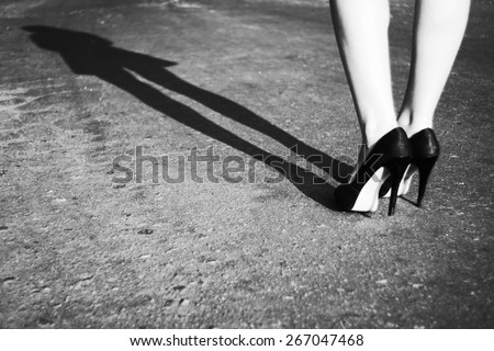 Shoes on feet. Female foot, women\'s shoes, women\'s long shadow. Black and white photo
