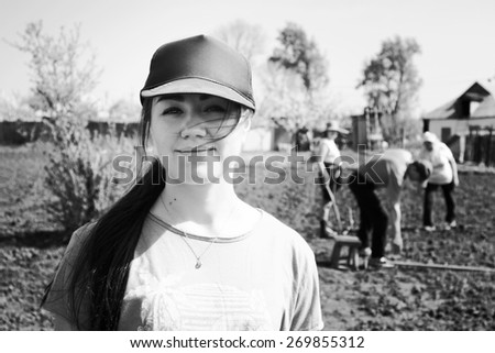 Workers in garden. Life in  village. Portrait of beautiful girl in cap. Black and white photo