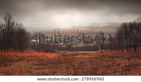 Rural landscape in mist. Panorama of village on spring morning. Anxious mood
