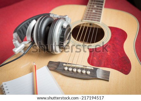 Notebook and pencil on guitar for writing music