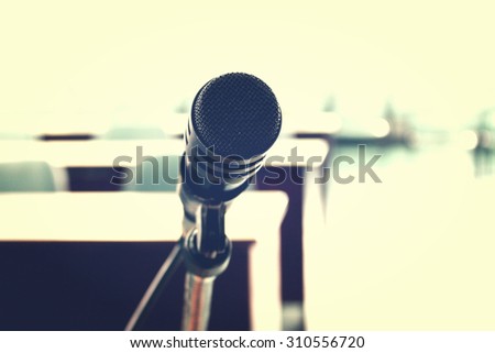 Microphone with blurred classroom background in vintage style, selective focus on the front of microphone