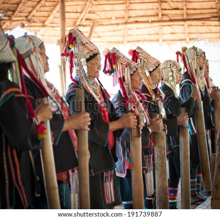 CHIANG RAI, THAILAND - DEC 4, 2013:Unidentified Akha hill tribe indigenous people dance in traditional clothes. Tourist travel tours to cultural villages are very popular. Folk costumes and jewelry