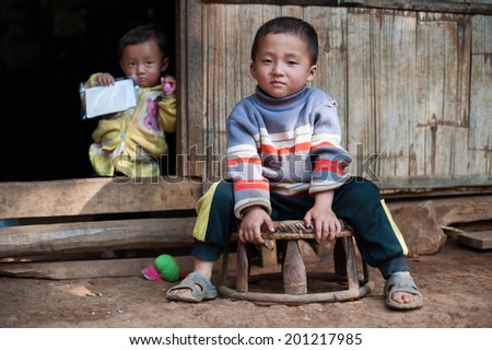LUANG PRABANG, LAOS - 9 DEC, 2014: Unidentified two kids in traditional village of Laos. Eco tourism is popular tourist attraction in Asia