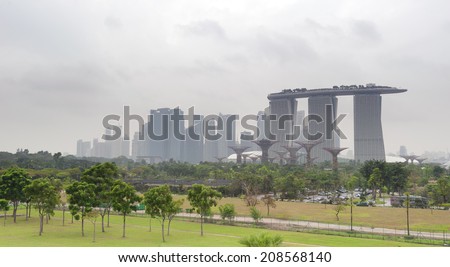 SINGAPORE - 31 DEC, 2013: Marina Bay Sands hotel - most expensive building in the world on city\'s skyline panorama. Famous Gardens By The Bay in the front of composition