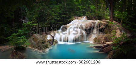 Exotic tropical waterfall in green jungle forest with plants and trees of rainforest. National park beautiful nature background