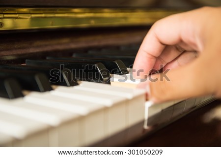 Man playing piano one hand, close up