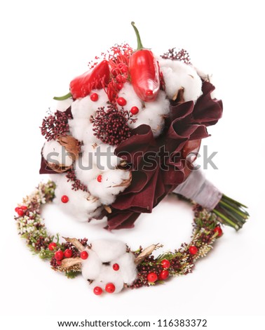 bouquet of cotton pods, red berries and red pepper on the background of a wreath