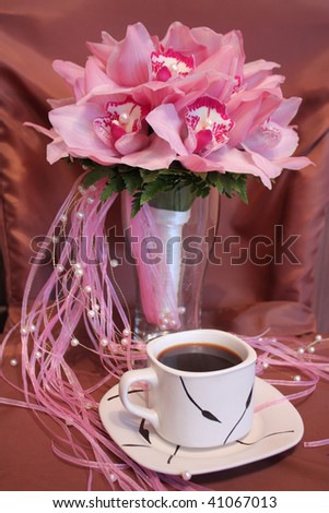 pink wedding bouquet of orchids and a cup of coffee