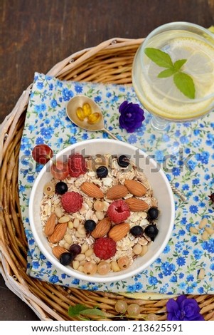 wholegrain flakes with fresh berries, nuts and milk on wooden table, horizontal