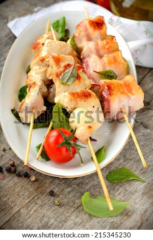 Chicken skewers with vegetables on wooden table