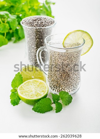 Chia seeds drink with water in transparent glass with lime and lemon balm. selective Focus