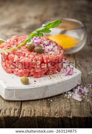Close up of beef tartar with capers gherkins, onions, and egg yolk. Selective fodus