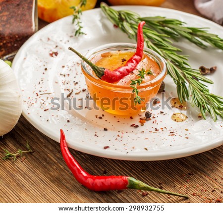 Home sweet hot sauce made with peaches and hot pepper to the meat in bowl with herbs, pepper and garlic on a ceramic plate on a wooden background. yborochny focus. concept of healthy homemade food