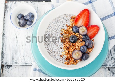 Chia seed pudding made with blueberries,  strawberriesvanilla and mint on a wooden background. Selective focus. The concept of good nutrition
